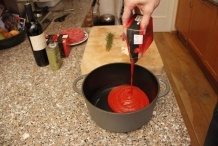 Giet de gezeefde tomaten in de pan